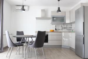 een keuken met een tafel en stoelen en een koelkast bij Apartment Luce in Trogir