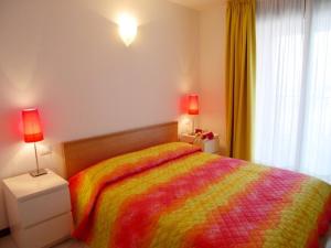a bedroom with a colorful bed and a window at Villa Olimpia in Grado