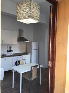 a kitchen with a white table and a table and a stove at Apartamentos La Concepción in Las Lagunas