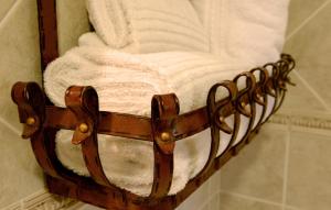 a wooden towel rack with white towels in a bathroom at The Woodpecker Inn in Pretoria