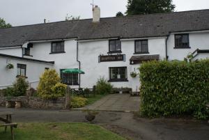 a white building with a sign that reads dragon inn at Scenery Cottage in Bridford