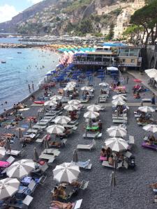 un gruppo di persone seduti su una spiaggia con ombrelloni di Casa Lilia ad Amalfi