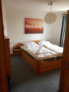 フェーマルンにあるFerienwohnungen Matschak OG rechtsの木製ベッド1台付きのベッドルーム1室(壁に絵画付)