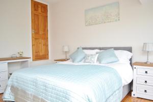 a bedroom with a bed with a blue and white comforter at Riverside Cottage in Wetherby +10 photos