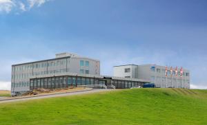 a large building with a grassy hill in front of it at Fosshotel Stykkisholmur in Stykkishólmur