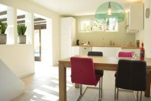 東卡佩勒的住宿－Vroonweg 34 sauna sunshower，厨房配有木桌和红色椅子