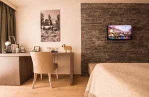 a living room with a tv and a bed at Hotel Daniela in Zermatt