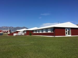 都皮沃古尔Helgafell Hostel的前面有草地的红色建筑