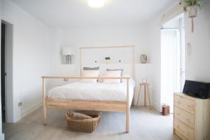 a bedroom with a white bed with a wooden frame at Triplex Panoramic Ronda in Ronda