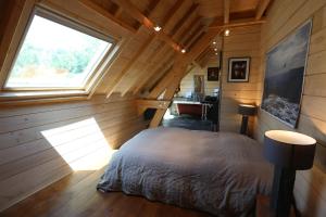 a bedroom in a log cabin with a bed and a window at Chalet Montagne in Saint-Pastous