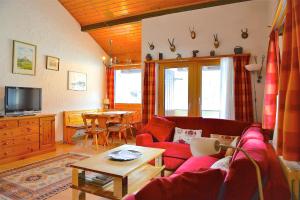 a living room with a red couch and a table at Chesa Panorama in Celerina