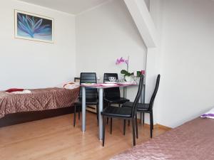 シュチェチンにあるApartamenty Centrumのテーブル、椅子、ベッドが備わる客室です。