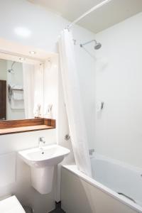 a white bathroom with a sink and a shower at Lobster Pot, Bridlington by Marston's Inn in Bridlington