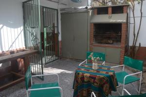 un patio con mesa, sillas y chimenea en Casa de Güemes Salta Capital en Salta