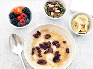 a bowl of oatmeal with fruit and other bowls of food at Charlotte Street Hotel, Firmdale Hotels in London