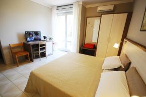 una camera con letto e scrivania con computer di Hotel Primavera a Barberino di Val dʼElsa