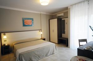 um quarto de hotel com uma cama e uma janela em Hotel Primavera em Barberino di Val dʼElsa