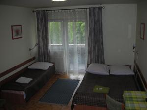 two beds in a room with a window at Zajazd Kosynier in Węgrzce +13 photos