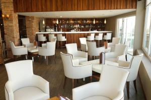 a restaurant with white chairs and a bar at Park Central Hotel in Bournemouth