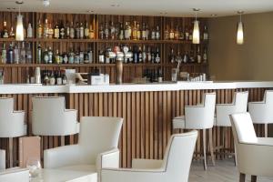 a bar in a restaurant with white chairs at Park Central Hotel in Bournemouth