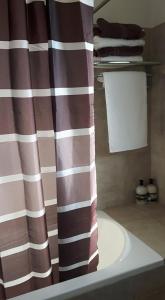 a bathroom with a shower curtain and a sink at Agrepavli Lapithia in Kallepia