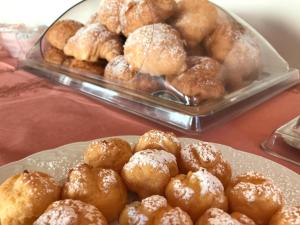 - une table avec une assiette de pâtisseries et un plateau de beignets dans l'établissement Hotel Villa Selene, à Lanusei