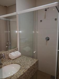 a bathroom with a sink and a glass shower at Hotel Sao Joao Itu in Itu