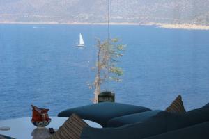 a table with a view of the water with a sailboat at Mandalina Suites in Kaş