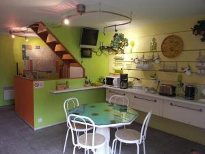 Una cocina con una mesa y sillas en una habitación. en Chambres d'Hôtes Au Grillon Dort, en Moustey