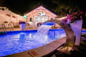 a pool with a water fountain in front of a house at Hotel Complex Dacha in Vinnytsya