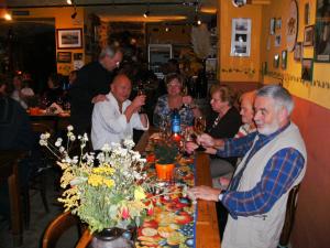 un gruppo di persone seduti intorno a un tavolo in un ristorante di Gastehaus Weingut Rossler a Lorch am Rhein