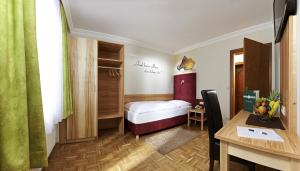 Zimmer mit einem Bett, einem Schreibtisch und einem Tisch in der Unterkunft Biergasthof Riedberg in Ried im Innkreis