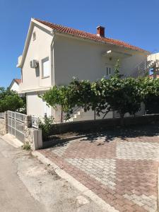 ein Haus mit einem Baum davor in der Unterkunft Apartmants Matić in Podaca