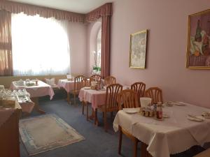 a dining room with tables and chairs and a window at Hotel Garni Keiml in Nuremberg