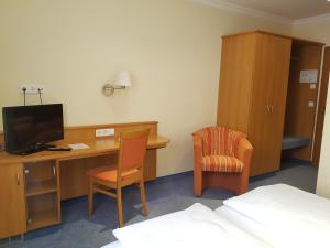 a room with a desk with a computer and a chair at Hotel Garni Keiml in Nuremberg