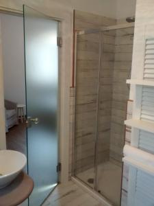 a shower with a glass door in a bathroom at La Pomella in Ponte Nizza