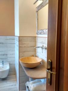 a bathroom with a wooden bowl sink and a mirror at La Pomella in Ponte Nizza