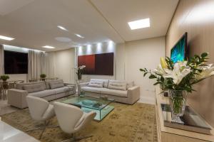 ein Wohnzimmer mit Sofas und einer Vase mit Blumen in der Unterkunft Leopoldo Hotel in Guanambi