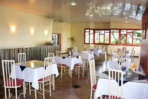 a dining room with white tables and chairs at Ana Maria Apart Hotel in Arcos