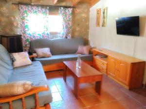 un soggiorno con divano e tavolo di Casa Rural en Aldea Cueva Ahumada a Villaverde de Guadalimar