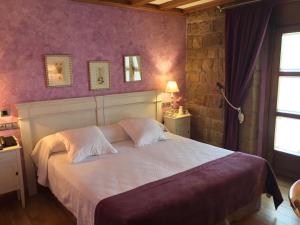 sypialnia z dużym łóżkiem i fioletowymi ścianami w obiekcie Posada Las Mayas w mieście Quintanar de la Sierra