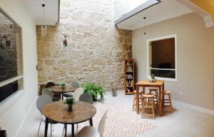 a room with tables and chairs and a brick wall at Albergue Gran Canaria in Las Palmas de Gran Canaria