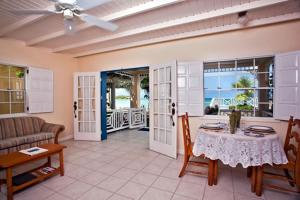 un soggiorno con tavolo e divano di Villa Beach Cottages a Castries