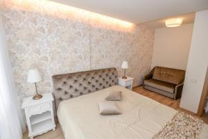 a bedroom with a large bed and a chair at IN24 in Palanga