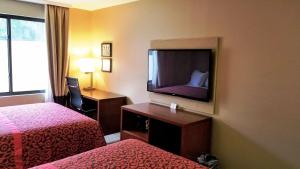 a hotel room with two beds and a flat screen tv at Days Inn by Wyndham Brooklyn Marine Park in Brooklyn