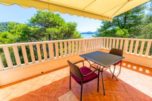 a balcony with a table and chairs on it at Rooms Karla in Polače