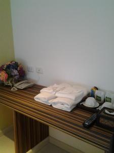 a pile of towels sitting on top of a desk at Nantra Ekamai Hotel in Bangkok