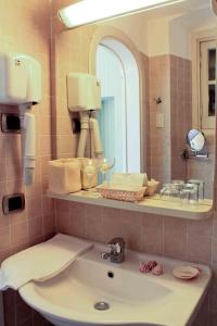 ein Bad mit einem Waschbecken und einem Spiegel in der Unterkunft Relais San Rocco in Sestri Levante