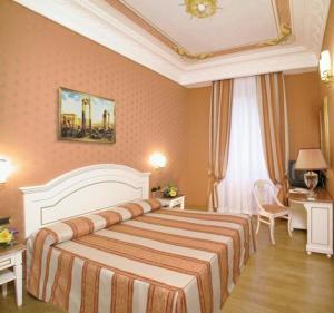 
a hotel room with a large bed and two lamps at Hotel La Lumiere Di Piazza Di Spagna in Rome
