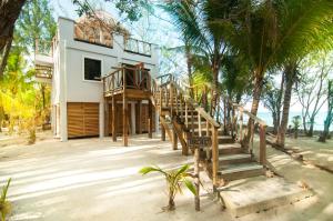 a staircase leading to a house on the beach at Thatch Caye Resort a Muy'Ono Resort in Hopkins